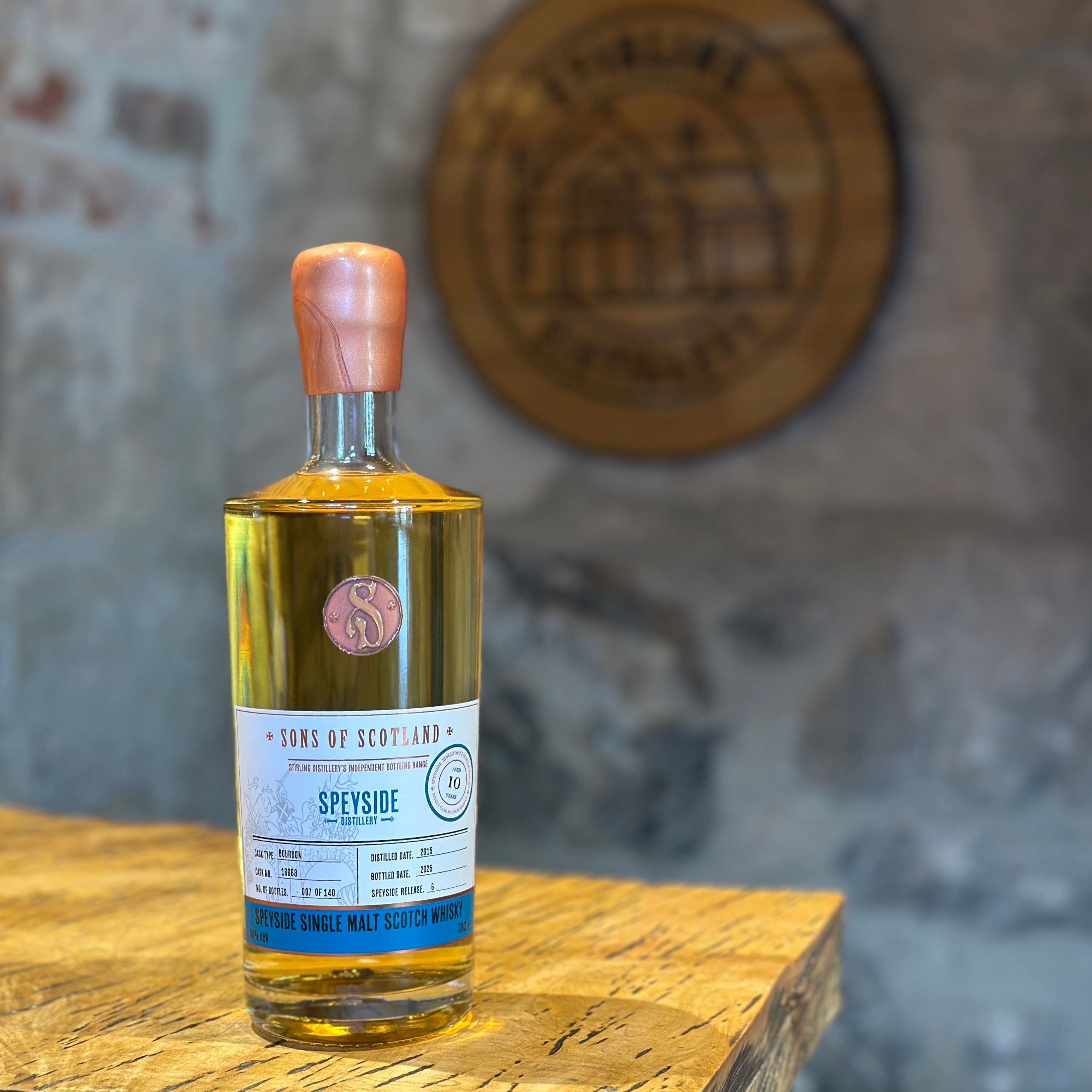 Bottle of Speyside  whisky on a wooden table with a blurred stonewall background