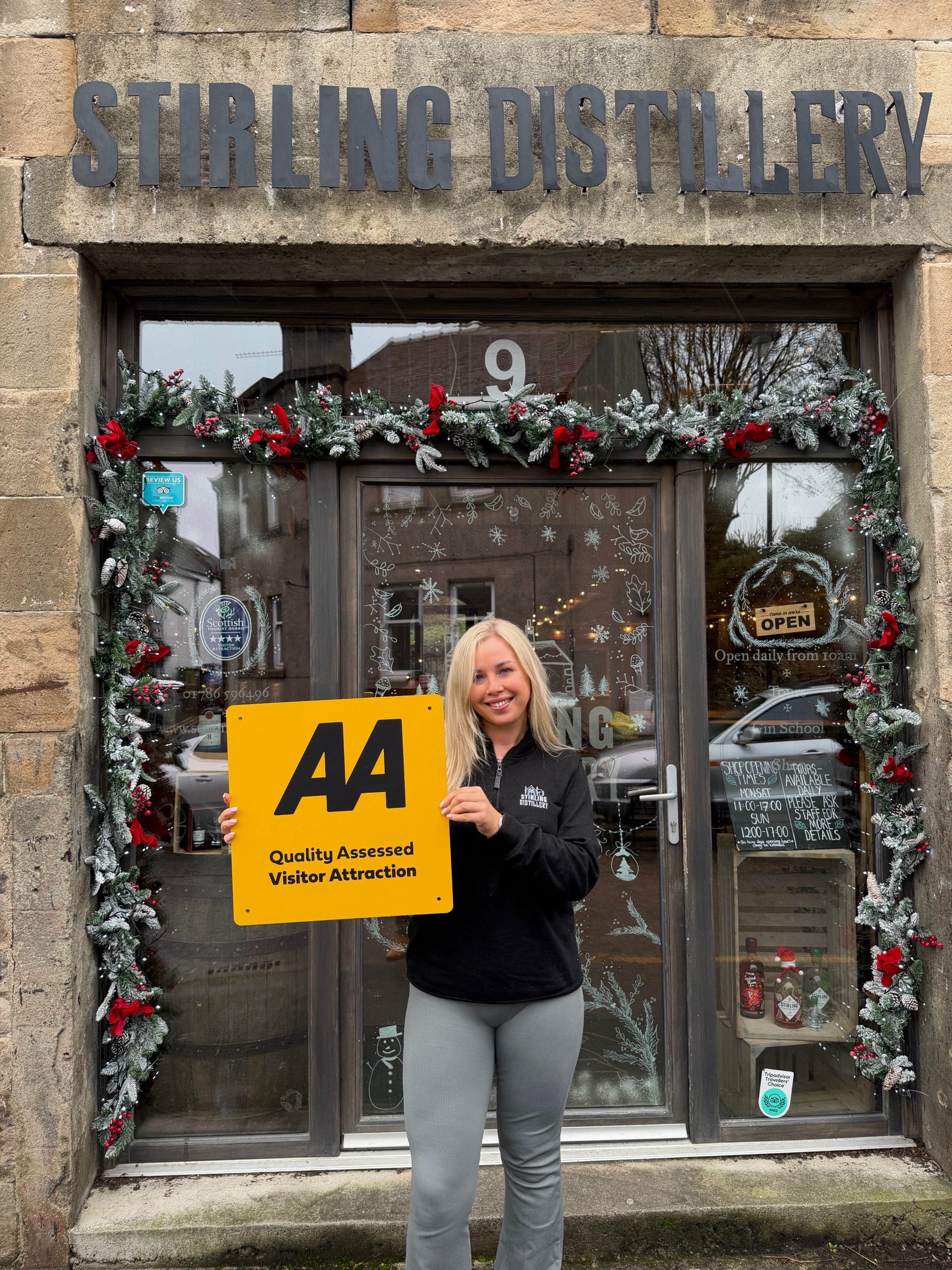 Elle McCann stands with AA award outside Christmassy distillery
