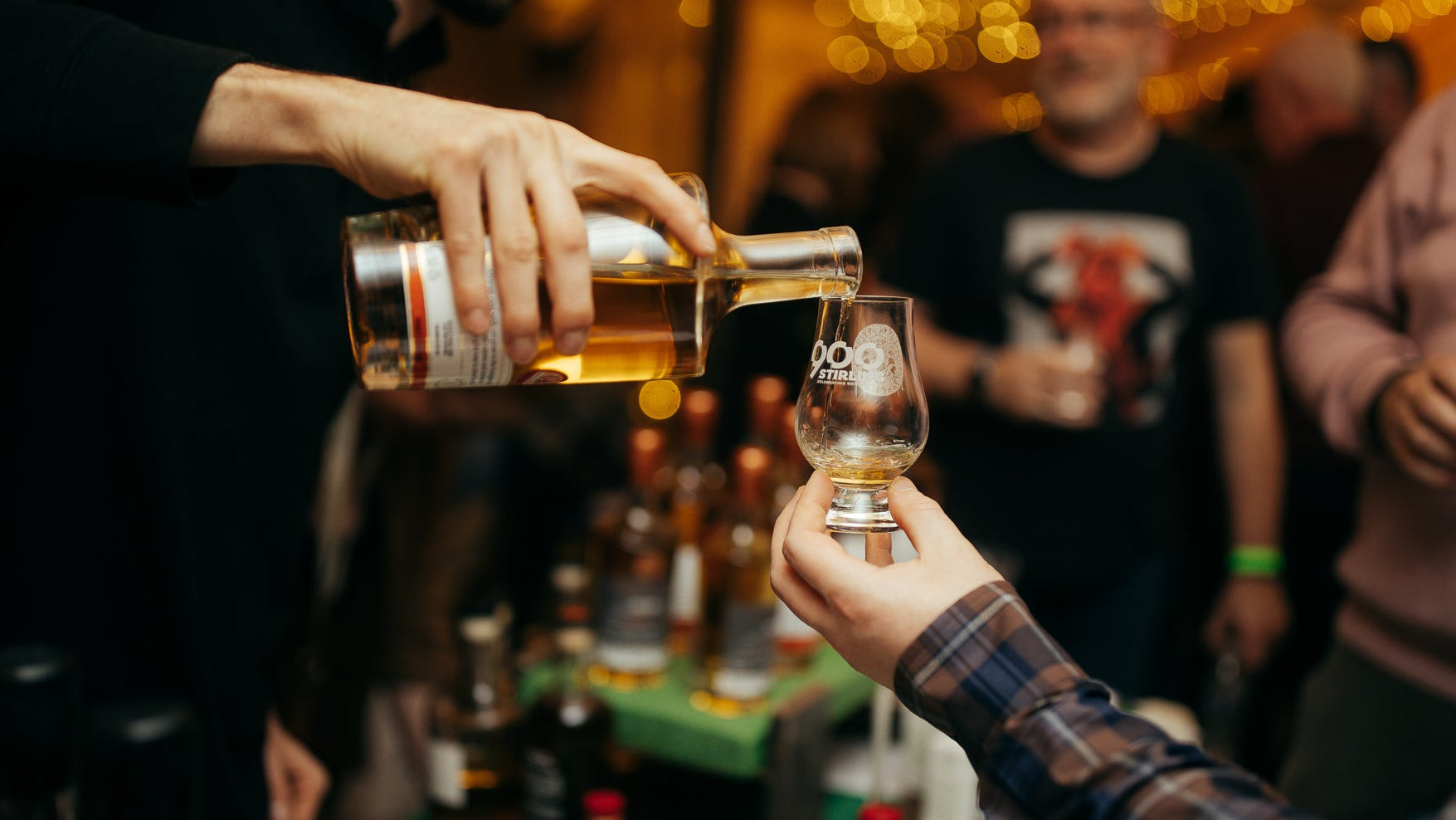 A bottle of whisky pouring into a glass