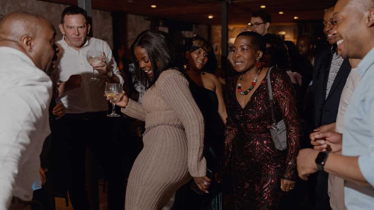 A group of happy people are dancing in the distillery.